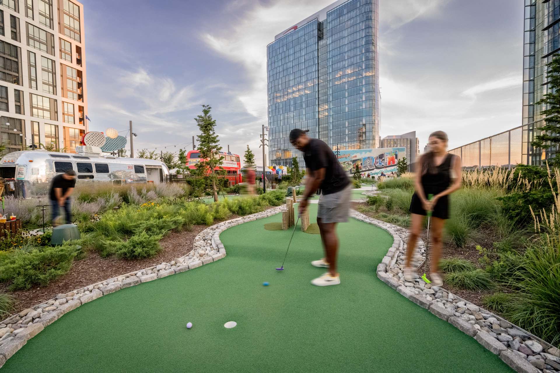 A man putting on a mini golf course in the neighborhood surrounding Heming