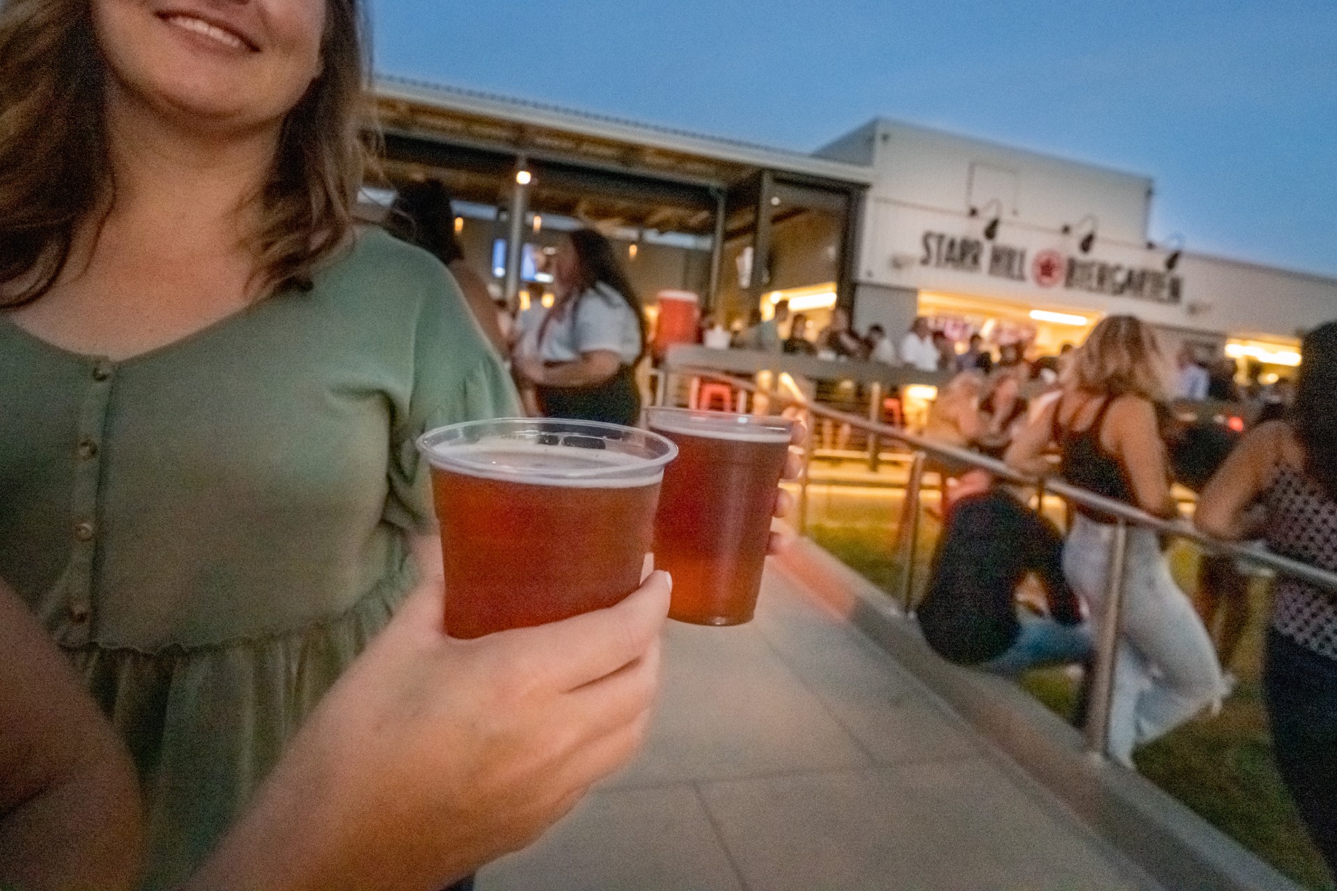 Photo of people doing a cheers with two pints of beer at a bar in the neighborhood near Heming apartments