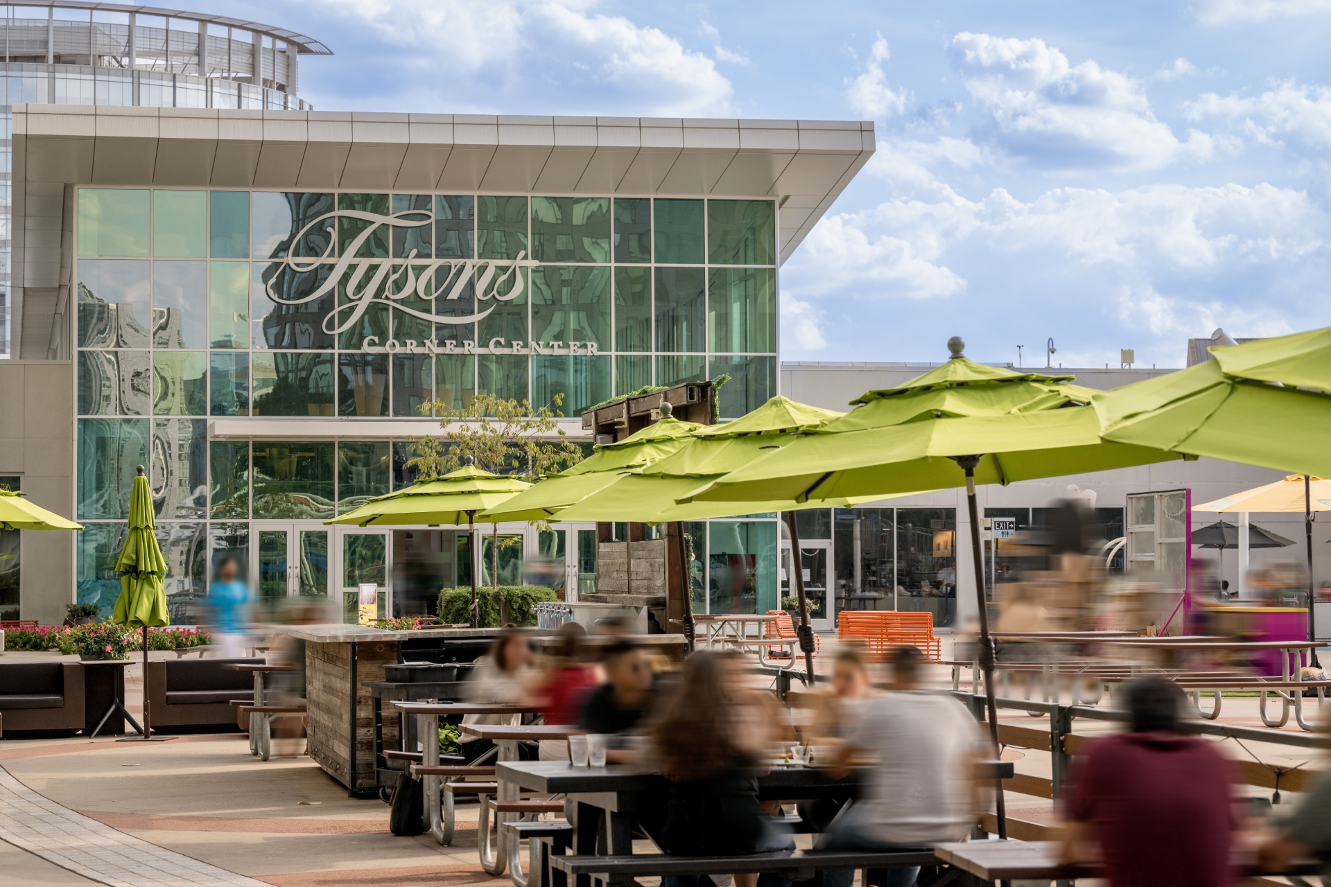 Tyson's Corner Center building with outside dining and seating featuring green umbrellas in the neighborhood near Heming apartments